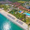 Vista aerea di resort con spiaggia, piscina e giardini.